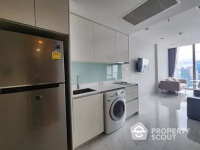 Sleek modern kitchen with stainless steel appliances and marble flooring opens to a cozy living area with city views, perfect for urban living.