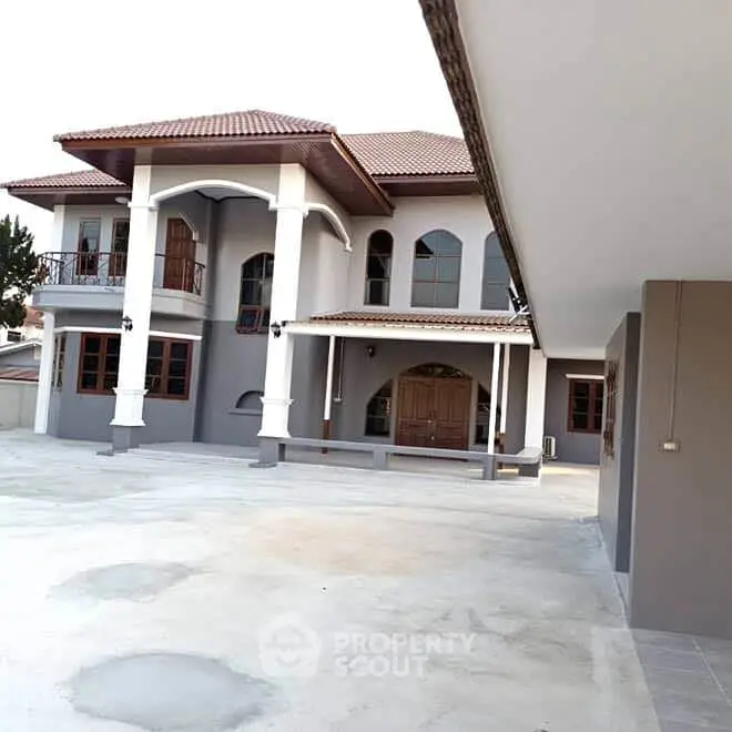 Elegant two-story house with spacious driveway and classic architectural design.