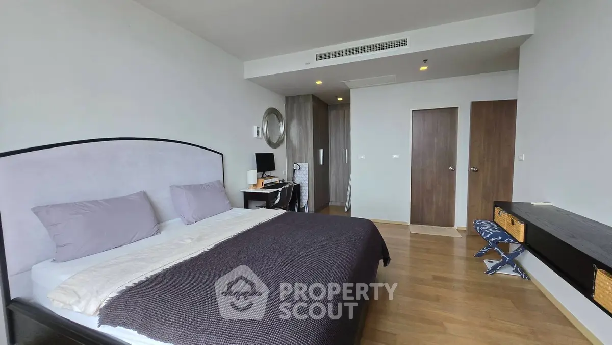 Spacious modern bedroom with stylish decor and ample natural light