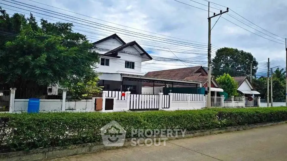 Charming suburban house with lush greenery and spacious driveway in a peaceful neighborhood.