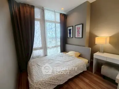 Cozy bedroom with modern decor and large window for natural light