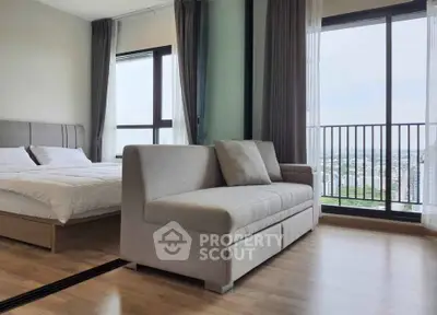 Modern bedroom with large windows and city view, featuring a cozy bed and stylish sofa.