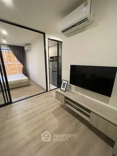 Modern apartment interior with sleek living room and cozy bedroom, featuring air conditioning and stylish decor.