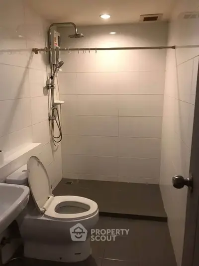 Modern bathroom with sleek shower and toilet in minimalist design.