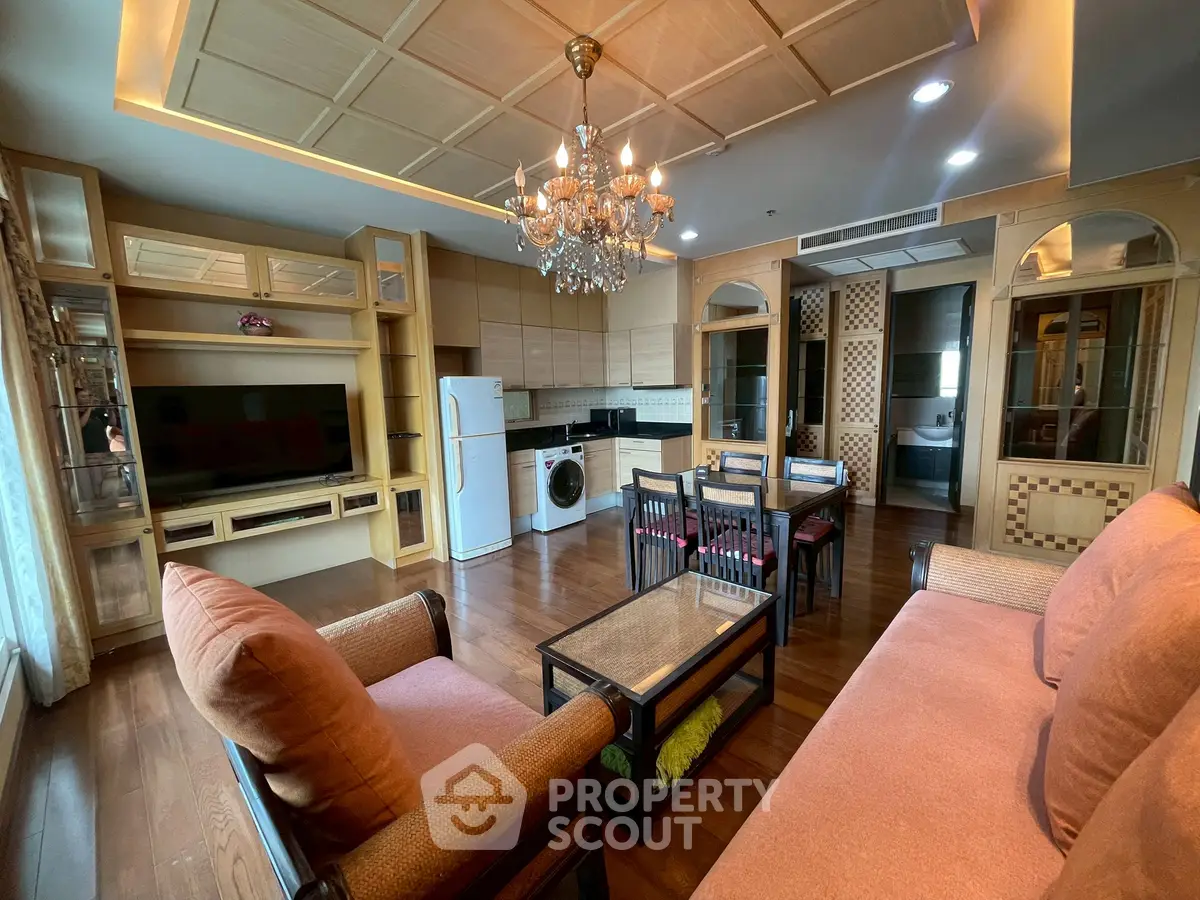 Luxurious living room with elegant chandelier and modern appliances in a stylish apartment.