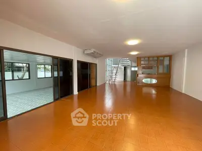 Spacious open-plan living area with tiled flooring and natural light