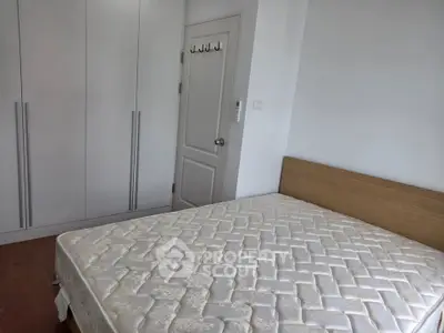 Spacious bedroom with built-in wardrobe and comfortable bed.