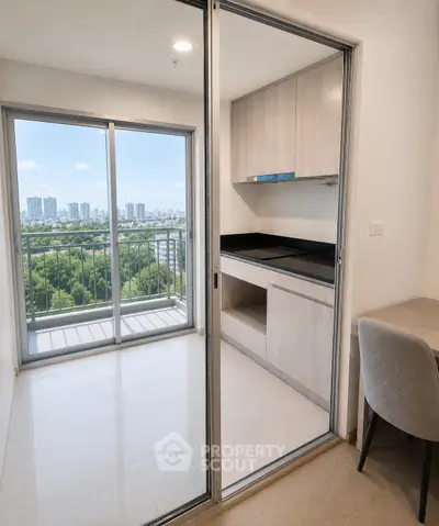Modern apartment with open kitchen and stunning city view from balcony.