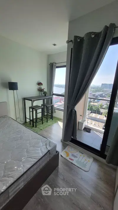 Modern bedroom with balcony and city view, featuring stylish decor and natural light.