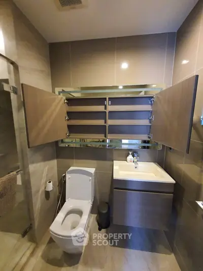 Modern bathroom with sleek fixtures and ample storage space, featuring a contemporary design and neutral tones.