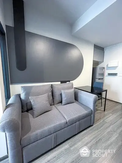 Modern living room with stylish gray sofa and contemporary wall design