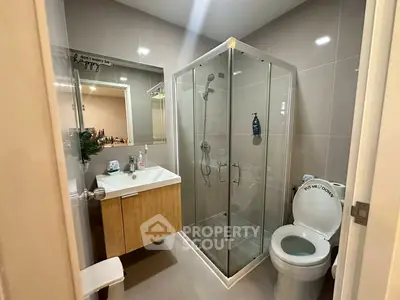 Modern bathroom with glass shower and sleek vanity in stylish apartment