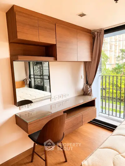 Modern bedroom with wooden furniture and balcony view, featuring a sleek desk and chair.
