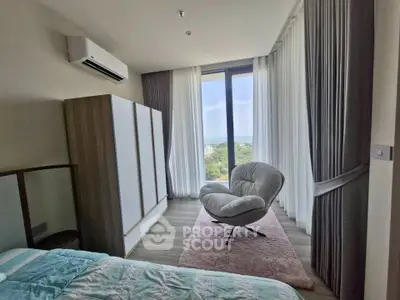 Modern bedroom with large window and stylish armchair offering scenic views