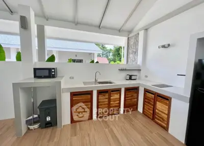 Modern open kitchen with sleek countertops and wooden cabinets in a bright, airy space.