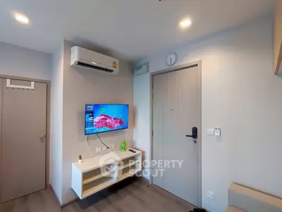 Modern living room with wall-mounted TV and air conditioning in a cozy apartment.