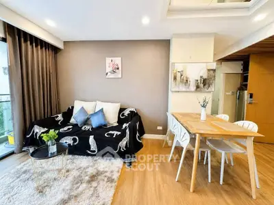 Modern living room with stylish decor and dining area in open layout apartment.