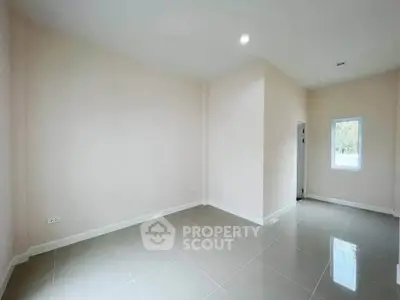 Spacious empty room with glossy tiled floor and natural light