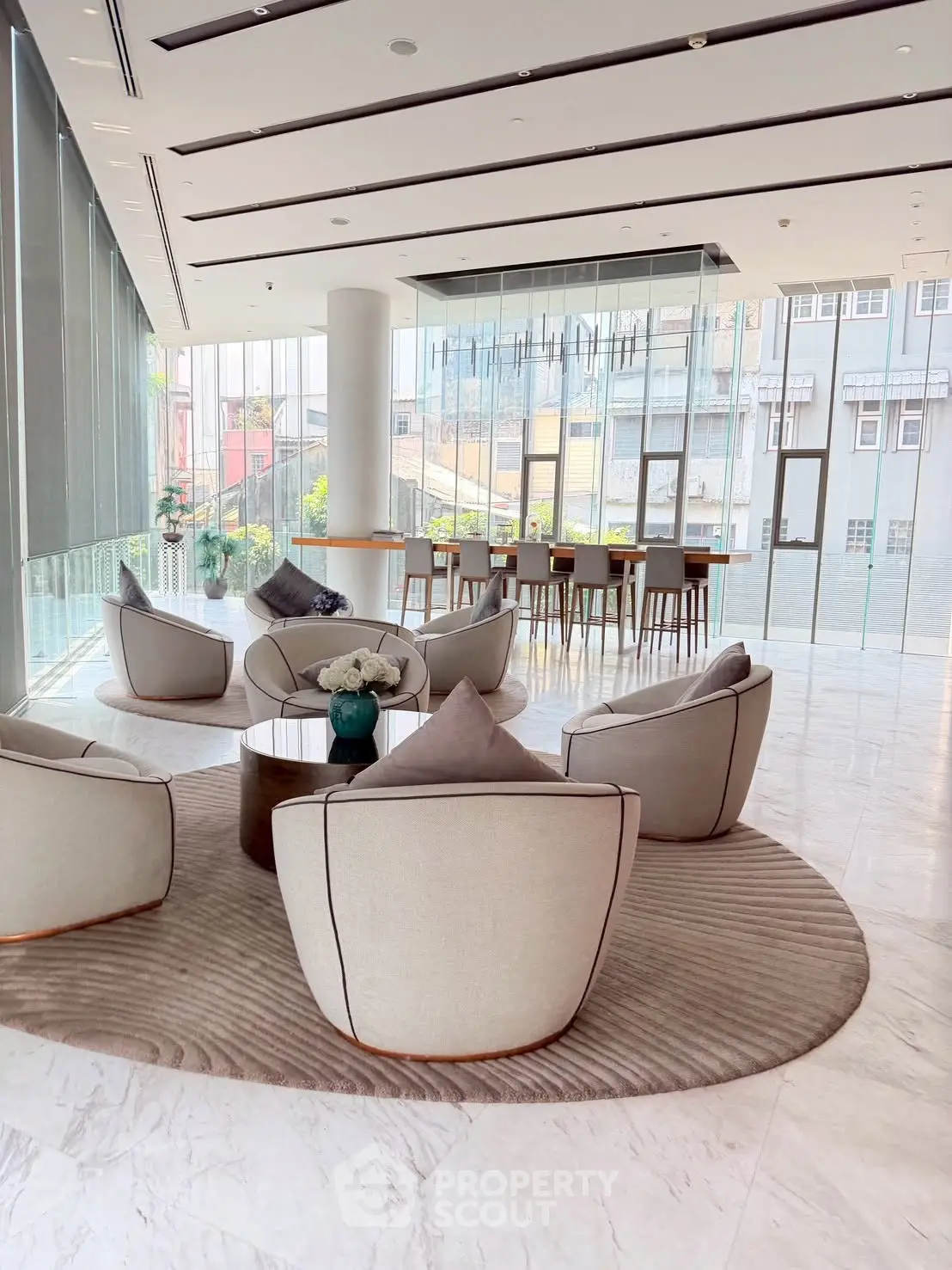 Luxurious modern lobby with elegant seating and floor-to-ceiling windows offering city views.
