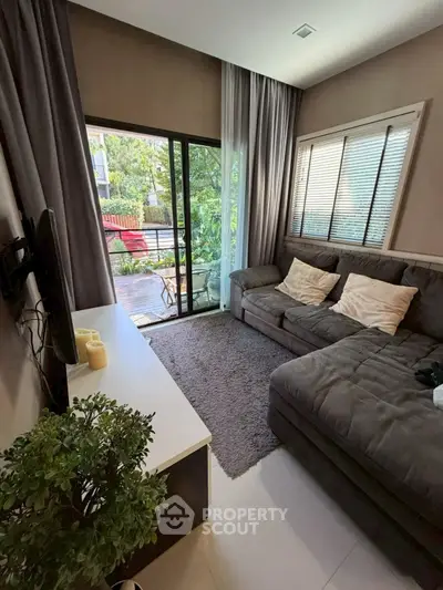 Cozy living room with large sofa and garden view, perfect for relaxation.