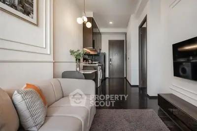 Modern living room with sleek kitchen, stylish decor, and cozy seating in a contemporary apartment.