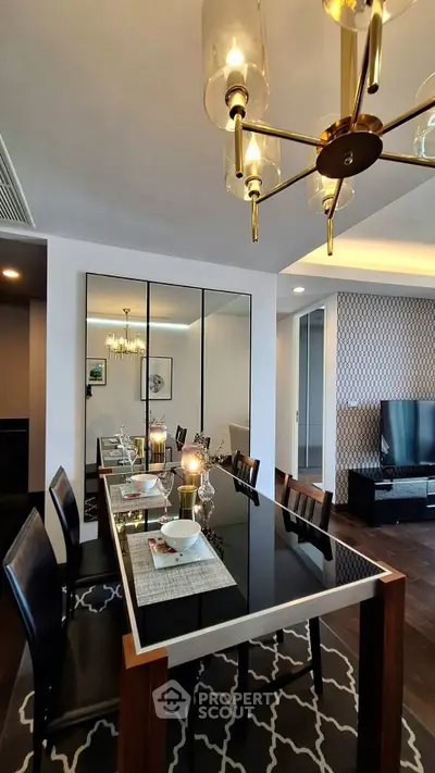 Elegant dining room with modern chandelier and mirrored wall, perfect for stylish entertaining.