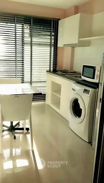 Modern kitchen with sleek appliances and washing machine, featuring large windows and stylish blinds.