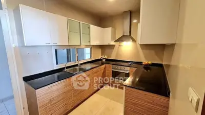 Modern kitchen with sleek cabinets and built-in oven in a stylish apartment.