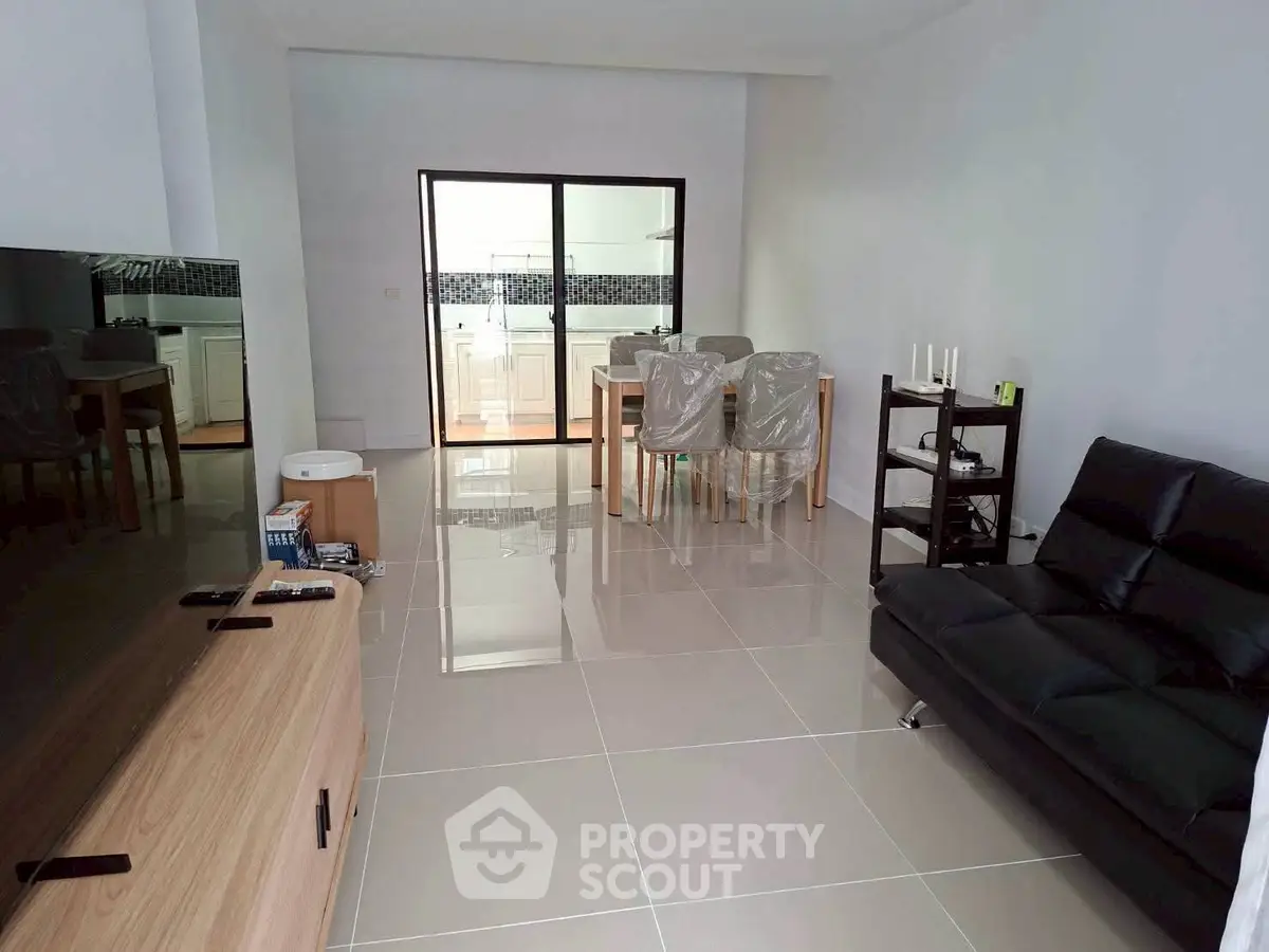 Modern living room with sleek furniture and open kitchen layout, perfect for contemporary living.