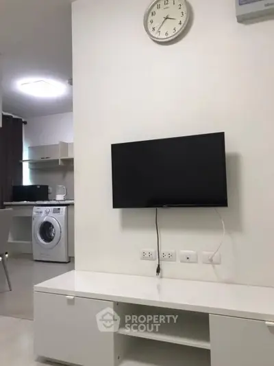 Modern living room with wall-mounted TV and open kitchen layout