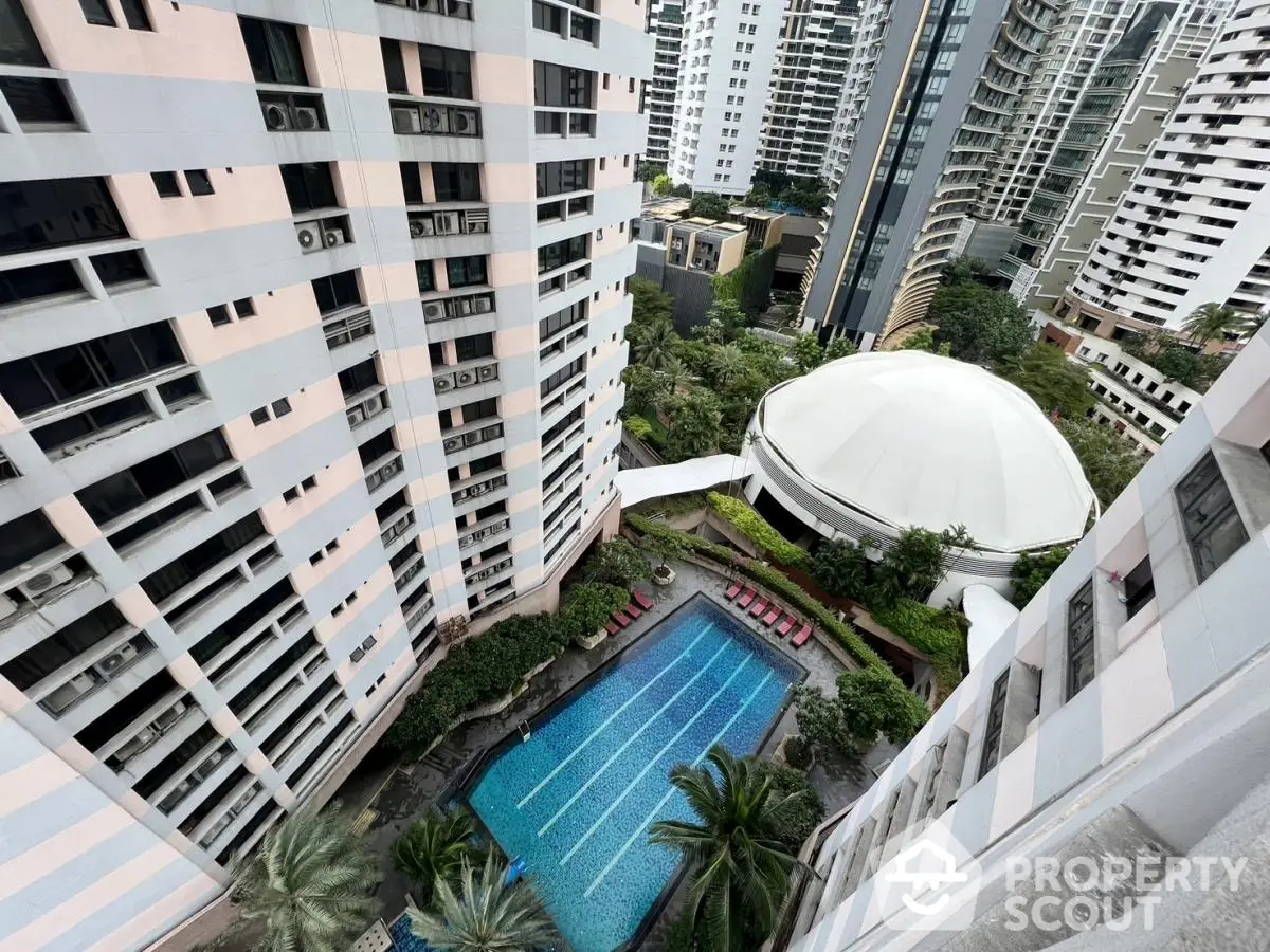 Stunning aerial view of luxury apartment complex with pool and lush greenery