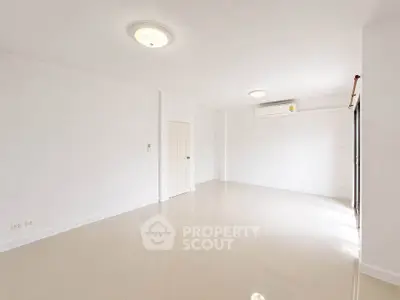 Spacious empty room with glossy tile flooring and bright lighting, perfect for customization.