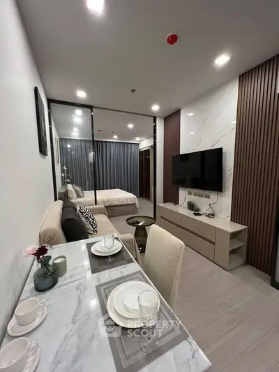 Modern studio apartment with open layout, featuring a cozy living area and stylish dining space.