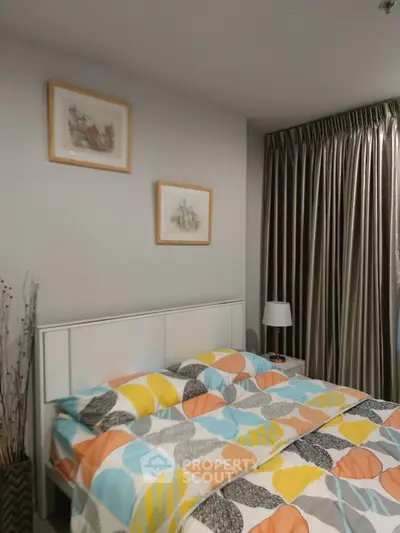 Cozy bedroom with colorful bedding and elegant curtains in modern apartment