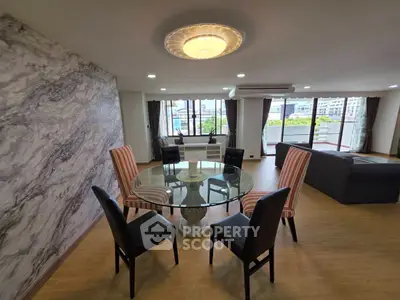 Spacious living room with elegant dining area and large windows offering a stunning view.