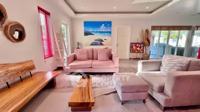 Stylish living room with modern furniture and beach-themed artwork, perfect for relaxation and entertaining.