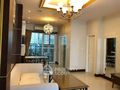 Elegant living room with modern chandelier and large windows in a stylish apartment.