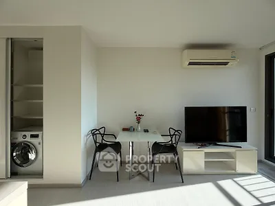Modern living room with sleek furniture and built-in laundry area