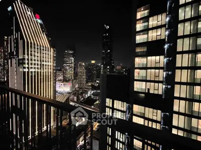 Stunning cityscape night view from high-rise balcony with illuminated skyscrapers.