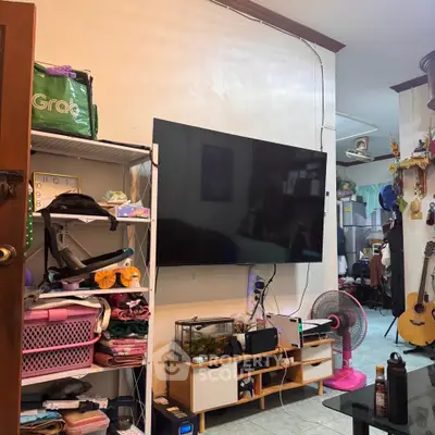 Cozy living room with wall-mounted TV, shelves, and modern decor in a stylish home.
