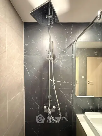Modern bathroom with sleek shower and elegant black marble tiles