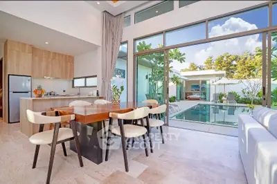 Luxurious open-plan living room with pool view, modern furniture, and abundant natural light.