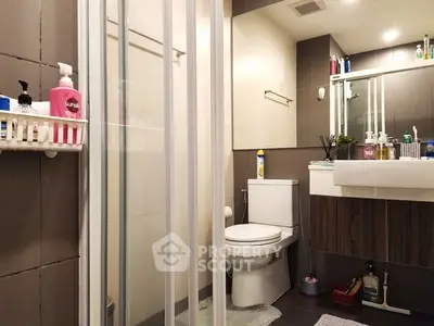 Modern bathroom with shower, toilet, and stylish sink in a cozy apartment.