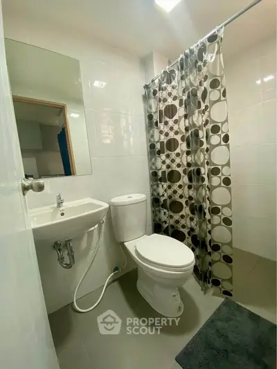 Modern bathroom with sleek fixtures and stylish shower curtain in a contemporary apartment.