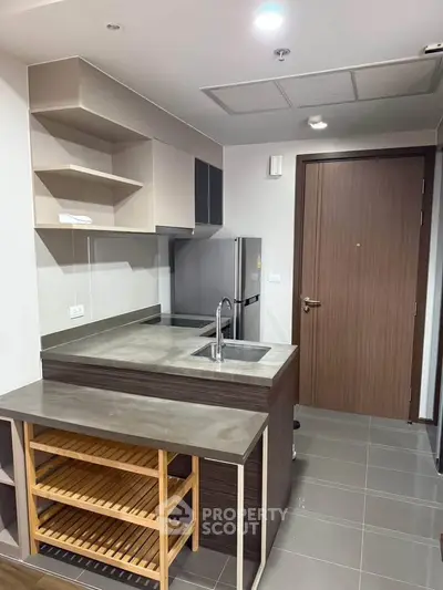 Modern kitchen with sleek design, featuring a compact island and stainless steel appliances.