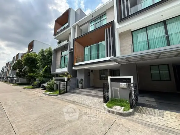 Modern townhouse exterior with sleek design and spacious balconies in a serene neighborhood.