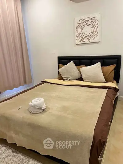 Cozy bedroom with elegant decor and plush bedding in a modern apartment.