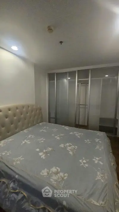 Spacious bedroom with elegant floral bedding and ample closet space