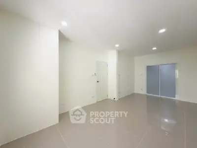 Spacious empty room with glossy tiled floor and modern lighting, ideal for customization.