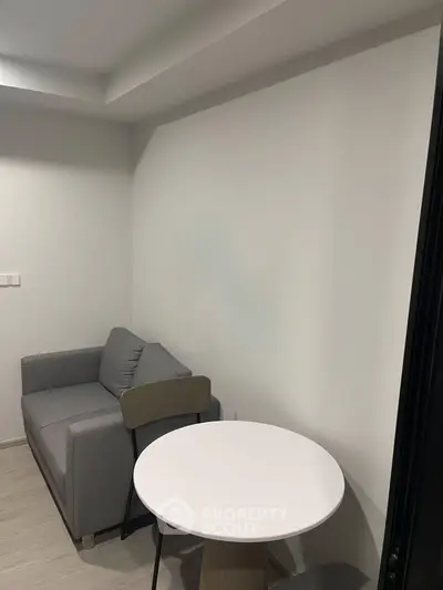 Cozy modern living room with gray sofa and round table, perfect for small spaces.